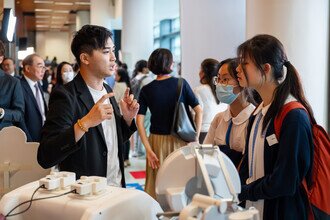 A research team member explains to secondary school students about the endoscopic surgical robot system EndoR developed by the CUHK.