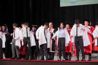 Procession members donned the white coats on freshmen