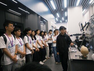 Participants closely observing a fascinating demonstration of advanced medical technology at the Multiscale Medical Robotics Centre